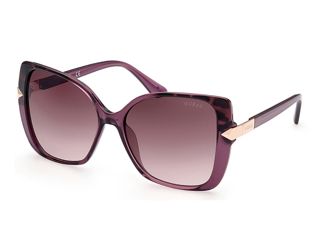 Lentes de sol Guess para mujer en color morado con cristales degradados y detalles laterales dorados.