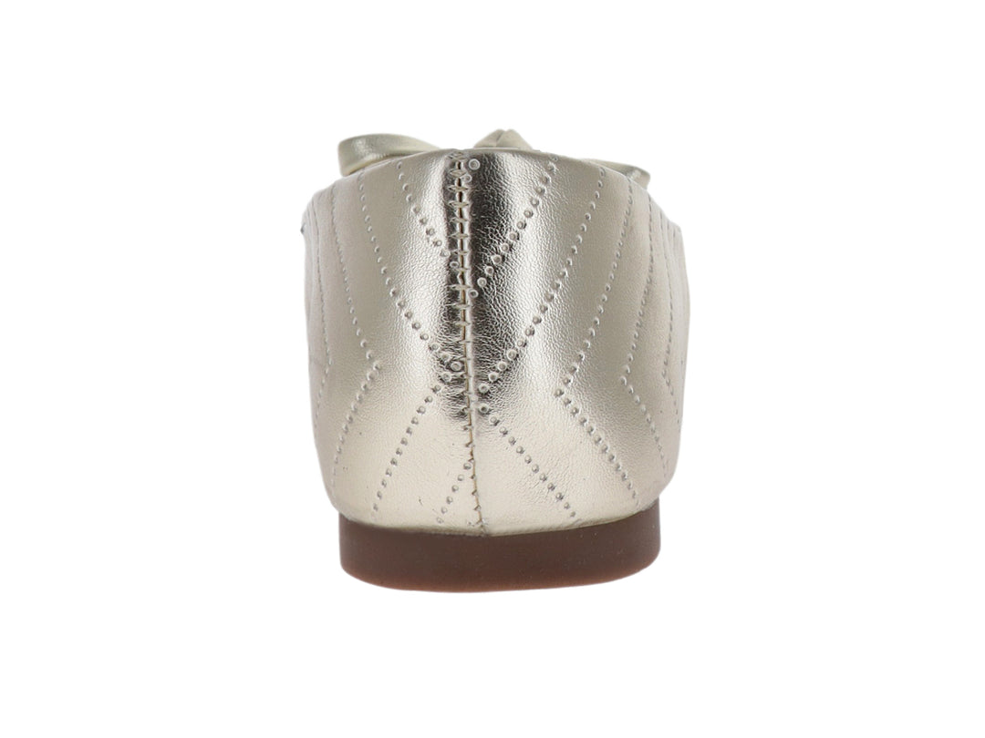 Zapato plano color oro con diseño en zigzag y moño decorativo en la punta.