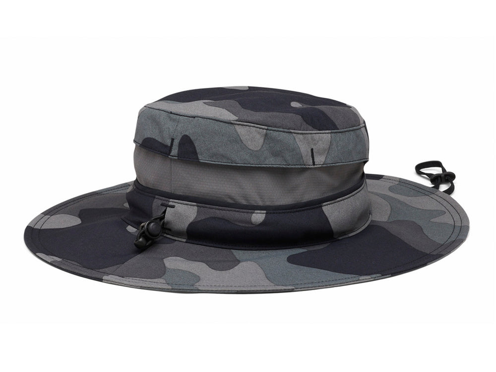 Sombrero Columbia Bora Bora Booney con estampado de camuflaje en tonos negro y gris, ideal para actividades al aire libre.