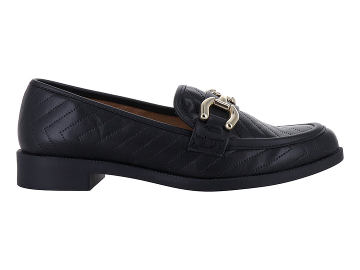 Mocasín negro de cuero con textura acolchada en zigzag y hebilla metálica dorada.