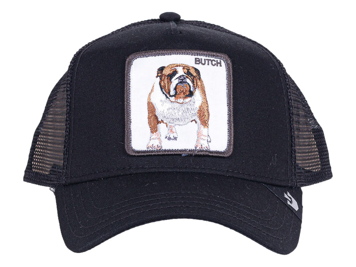 Gorra negra Goorin Bros con visera curva y parche frontal bordado de un perro bulldog blanco y café llamado Butch.