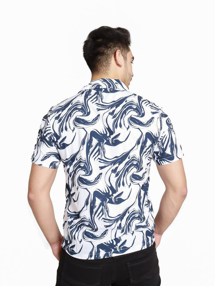 Hombre vistiendo camisa de manga corta blanca con estampado abstracto en color azul.