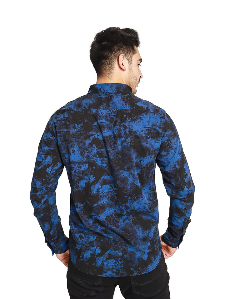 Hombre vistiendo camisa de manga larga con estampado abstracto en colores azul y negro.