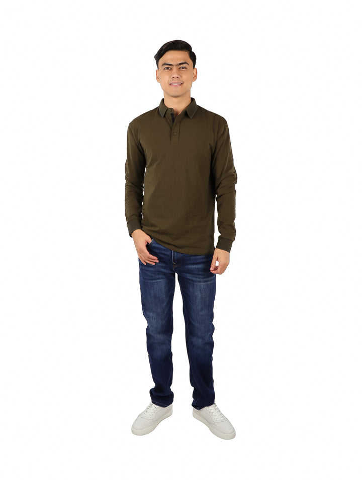 Hombre usando una playera polo de manga larga color verde olivo y jeans azules.