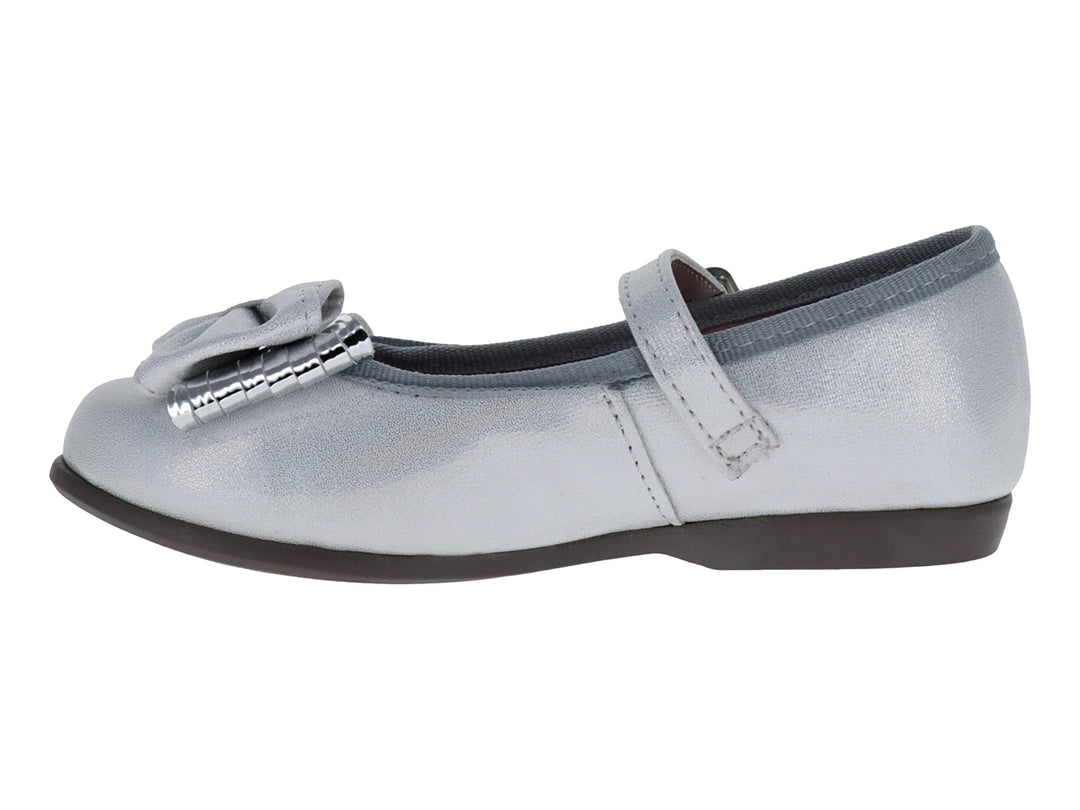 Zapato plano blanco brillante para niña con moño decorativo y correa ajustable.