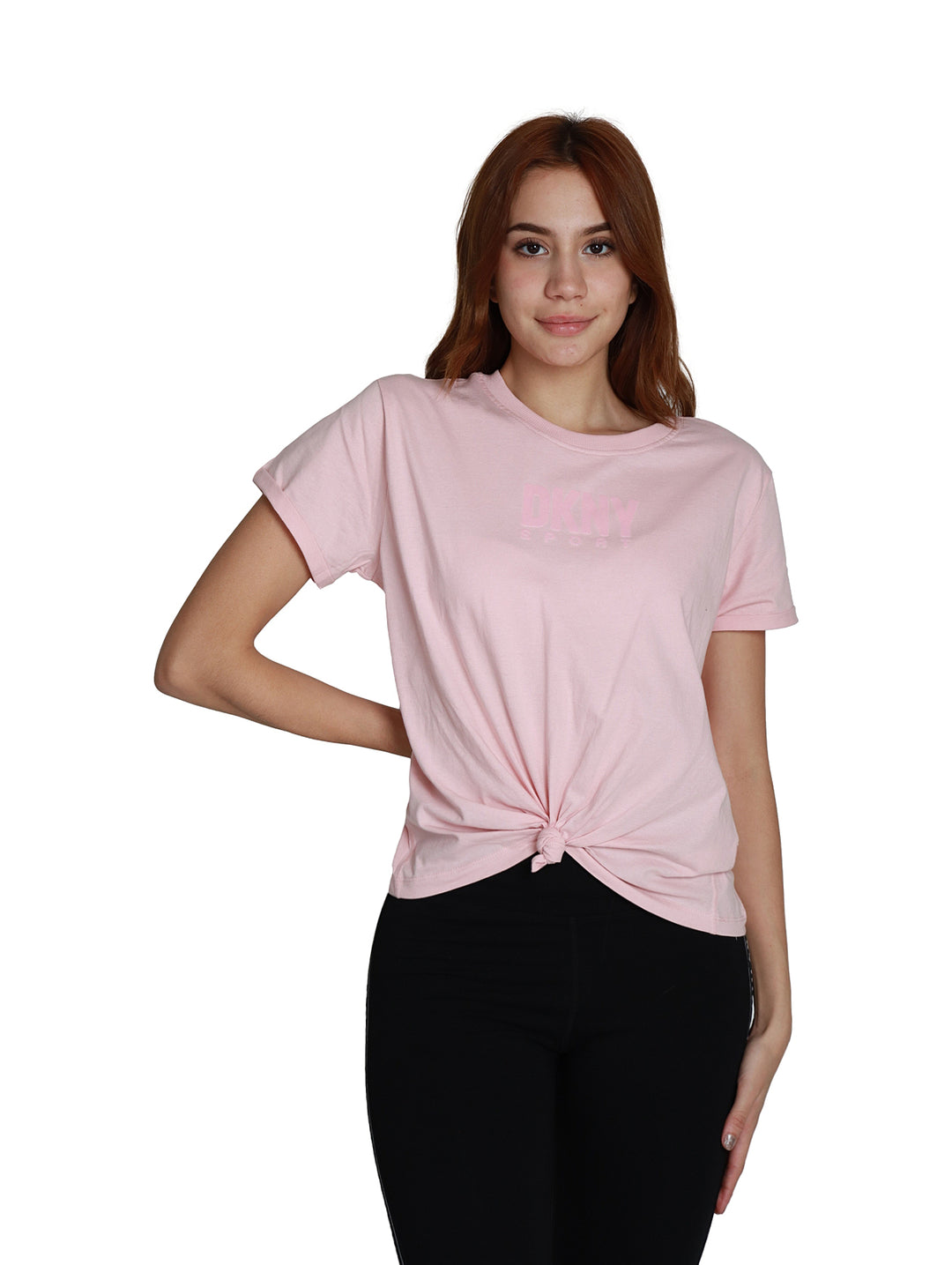Mujer vistiendo una camiseta rosa claro DKNY de manga corta con un nudo decorativo en la parte frontal.