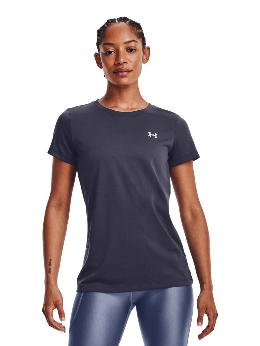 Mujer vistiendo una camiseta deportiva de manga corta color gris oscuro de la marca Under Armour.