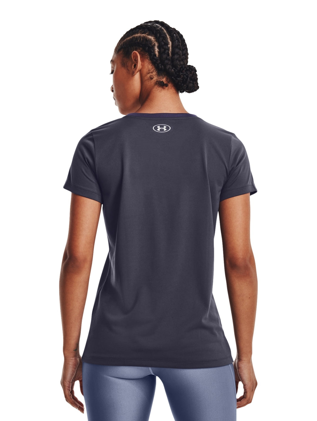 Mujer vistiendo una camiseta deportiva de manga corta color gris oscuro de la marca Under Armour.