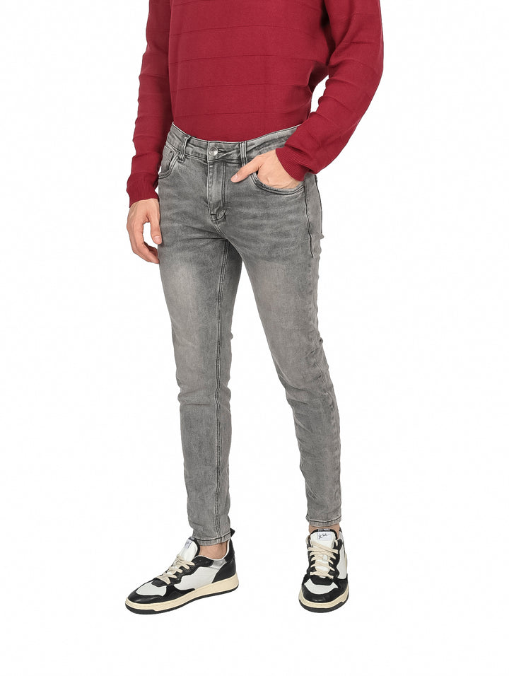 Hombre vistiendo pantalones jeans ajustados en color gris y un suéter rojo.