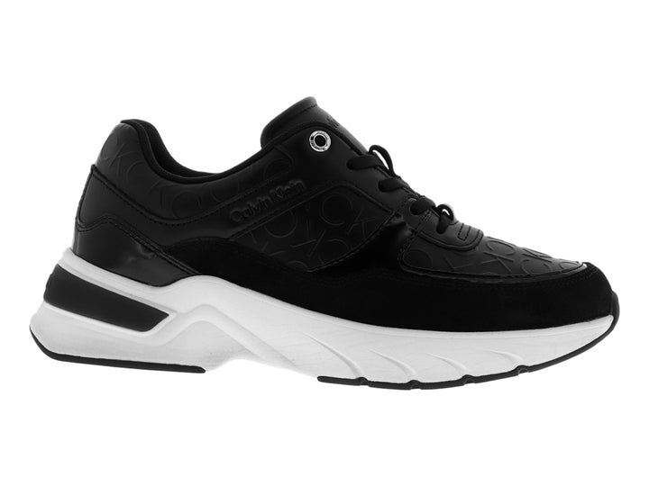 Tenis Calvin Klein en color negro con suela blanca ancha y detalles grabados en la parte superior.