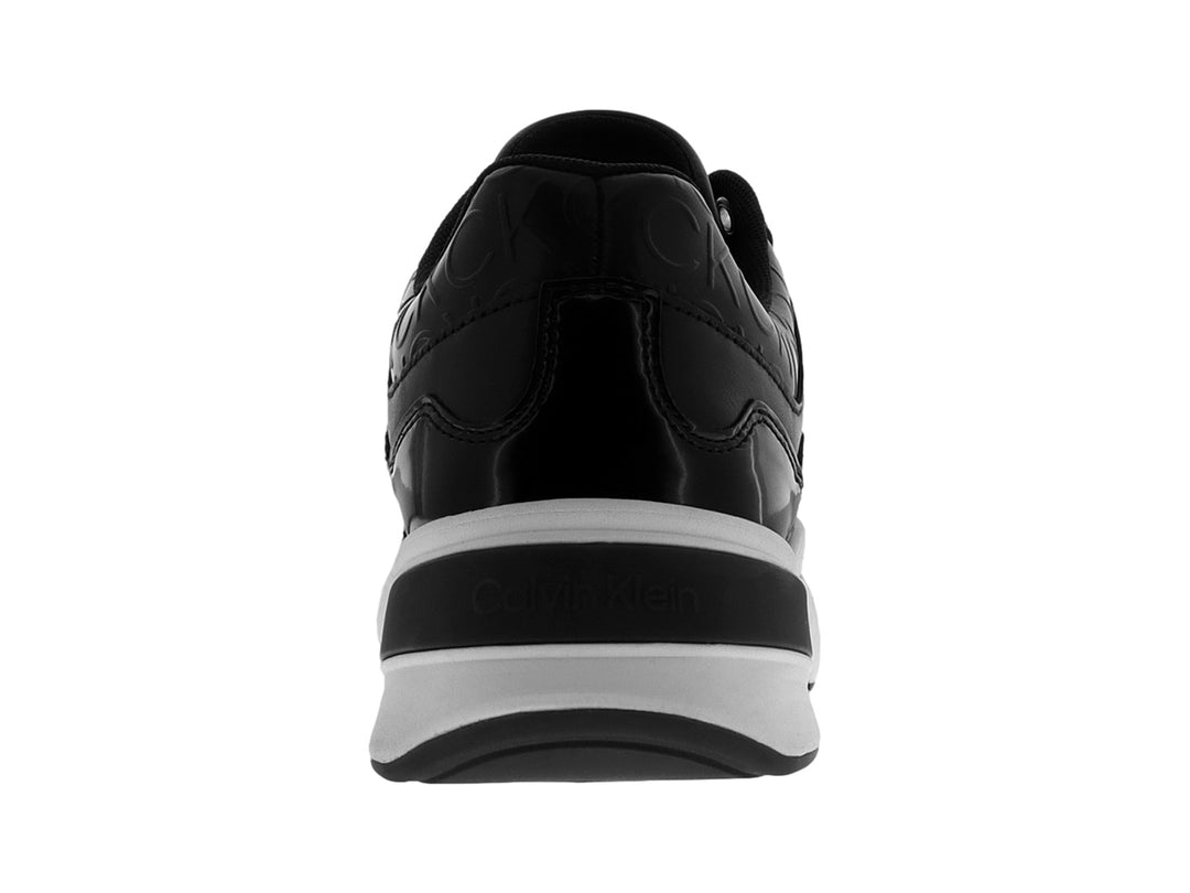 Tenis Calvin Klein en color negro con suela blanca ancha y detalles grabados en la parte superior.