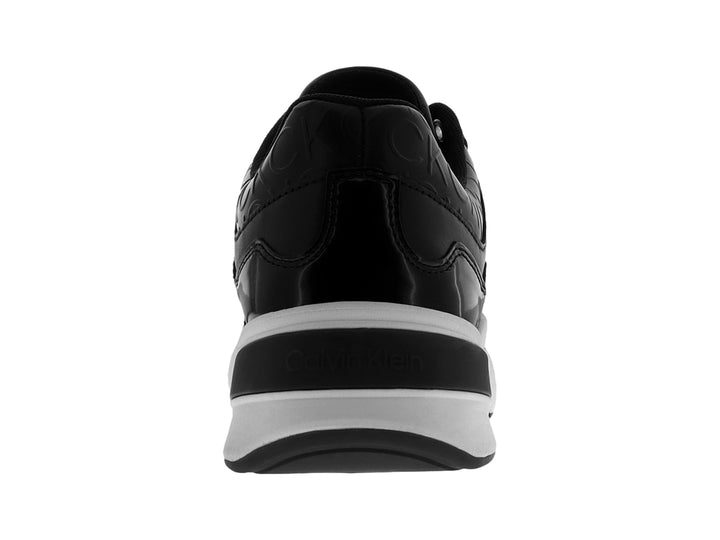 Tenis Calvin Klein en color negro con suela blanca ancha y detalles grabados en la parte superior.