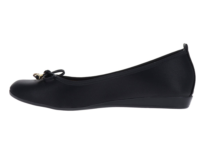 Zapato plano color negro para mujer con detalle decorativo dorado en el empeine.