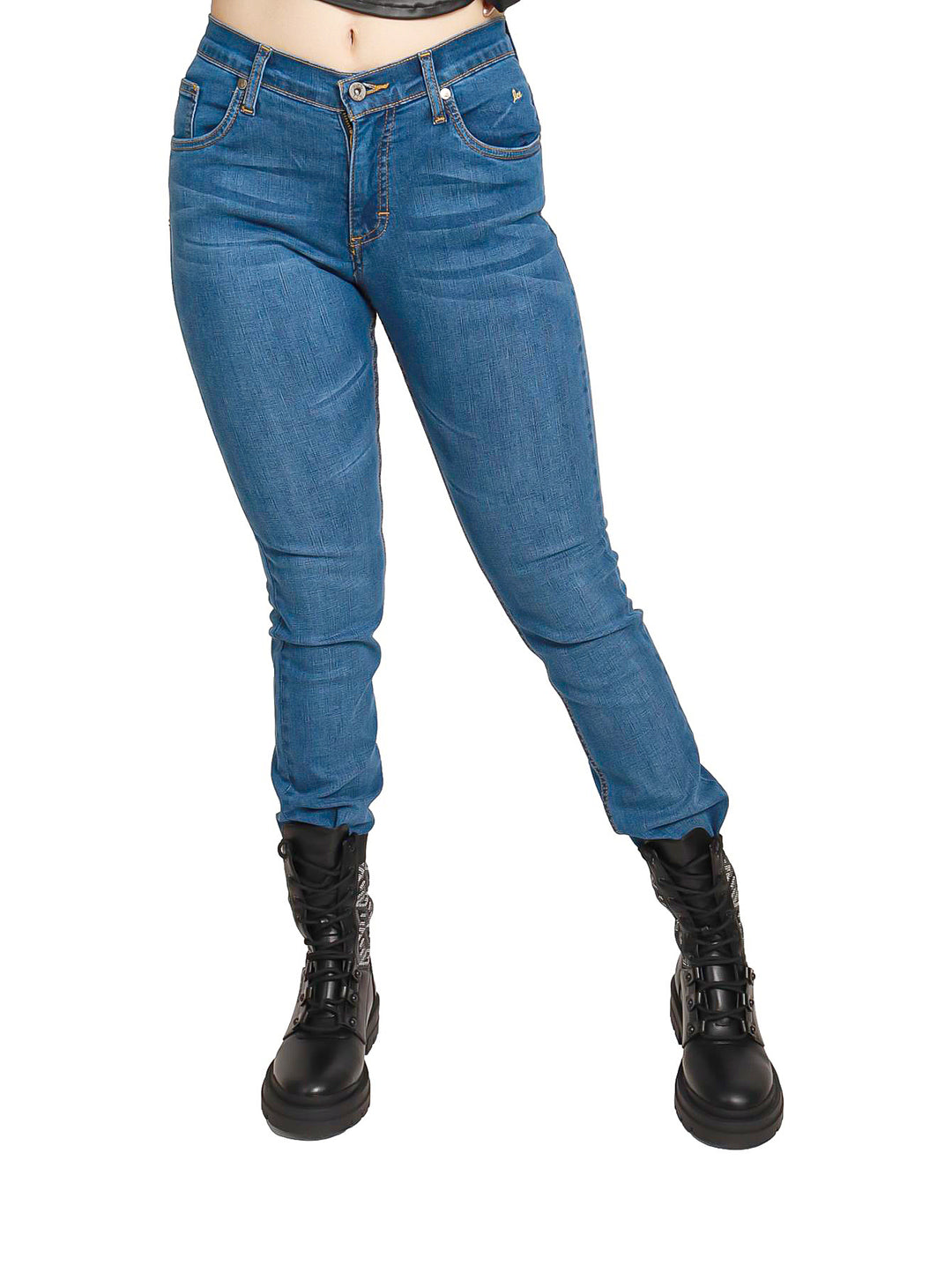 Mujer vistiendo jeans skinny color azul de cintura alta y botas negras.