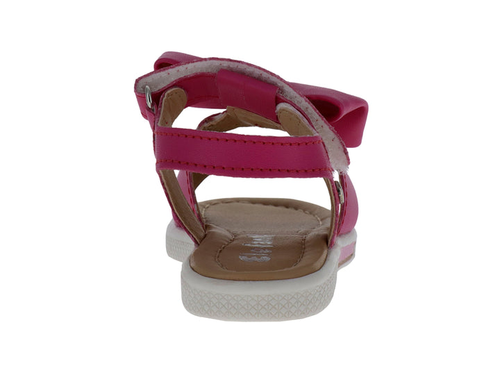 Sandalia infantil color fucsia con un moño decorativo en la parte superior y suela blanca.