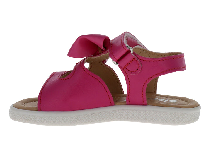 Sandalia infantil color fucsia con un moño decorativo en la parte superior y suela blanca.