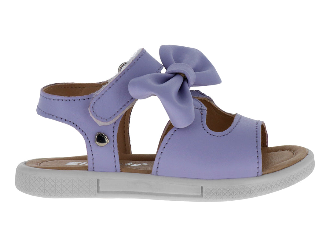 Sandalias infantiles color lavanda con un moño decorativo en la parte superior y suela blanca.