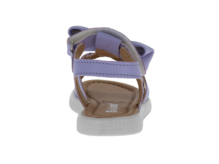 Sandalias infantiles color lavanda con un moño decorativo en la parte superior y suela blanca.