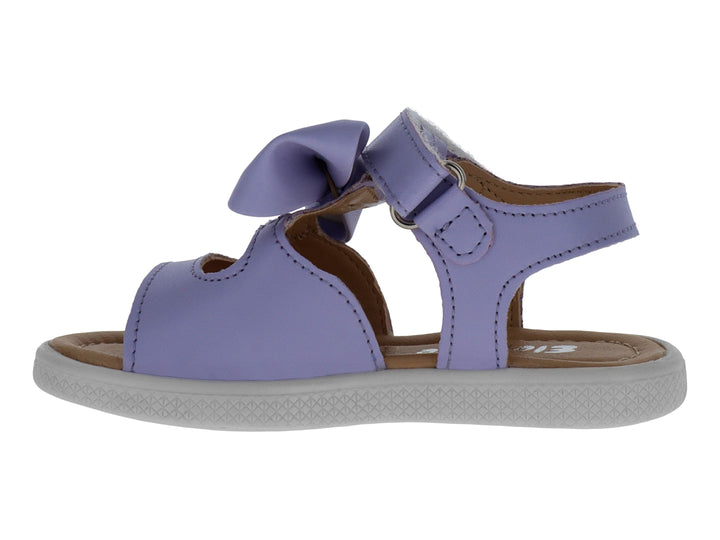 Sandalias infantiles color lavanda con un moño decorativo en la parte superior y suela blanca.