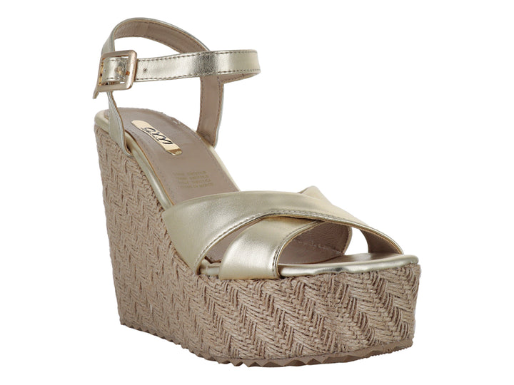 Sandalia de plataforma color oro metálico con correa al tobillo y suela texturizada en tono beige para mujer.