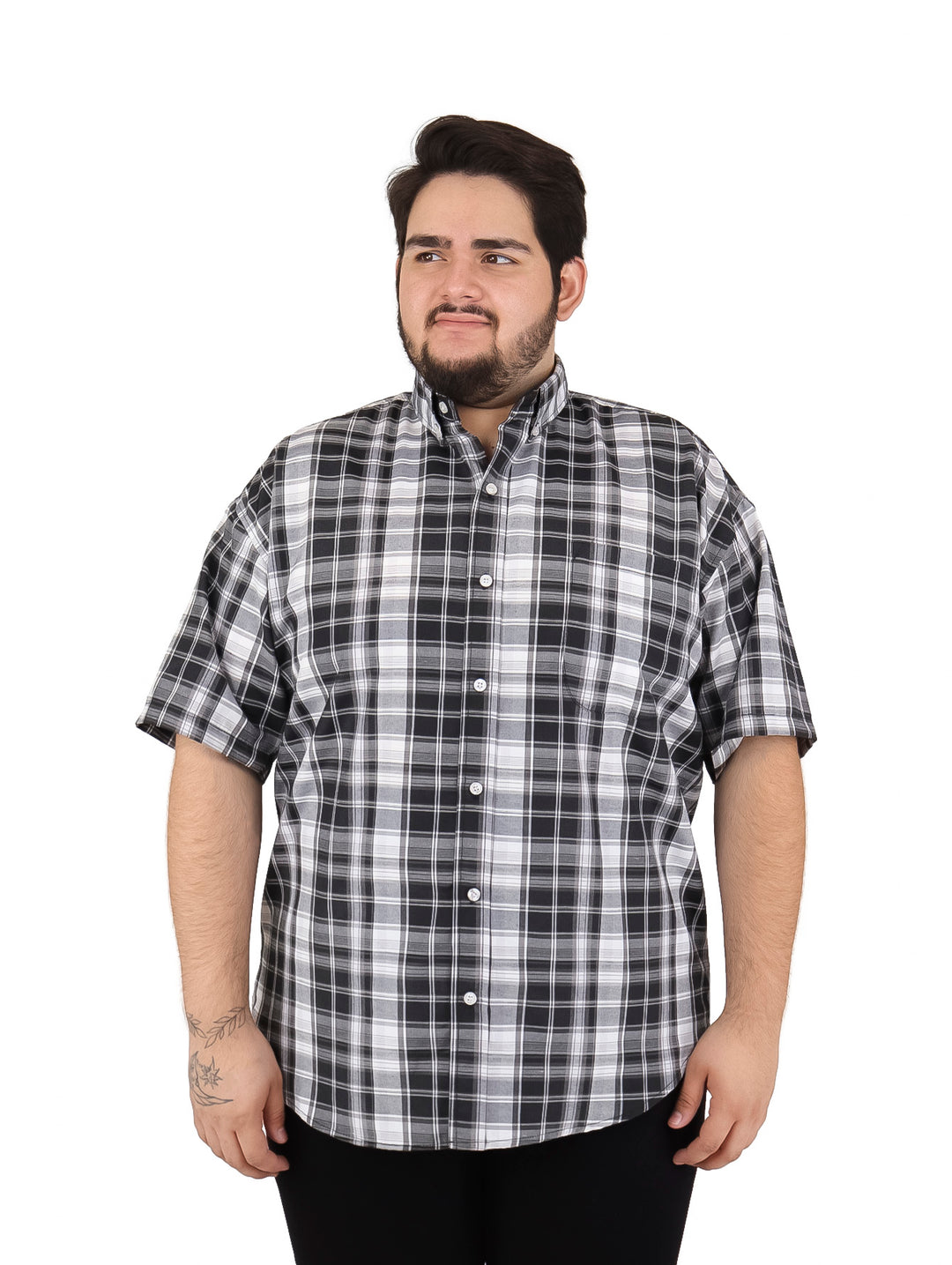 Hombre vistiendo camisa de manga corta con estampado de cuadros en colores negro y blanco.