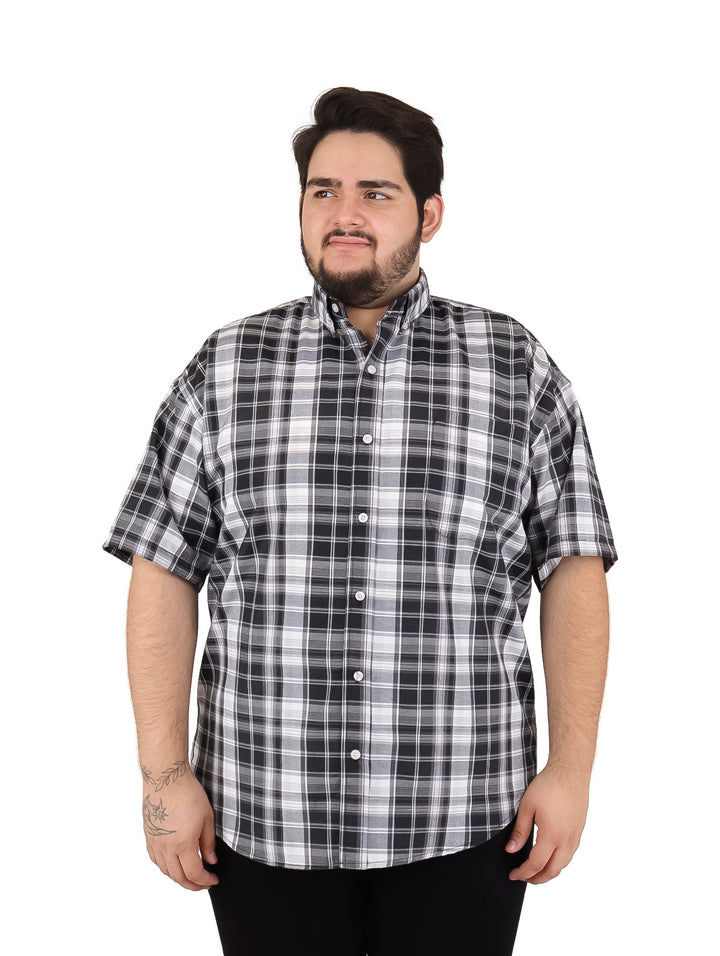 Hombre vistiendo camisa de manga corta con estampado de cuadros en colores negro y blanco.