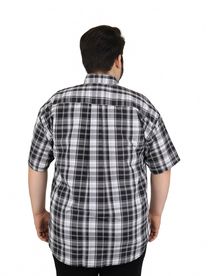 Hombre vistiendo camisa de manga corta con estampado de cuadros en colores negro y blanco.