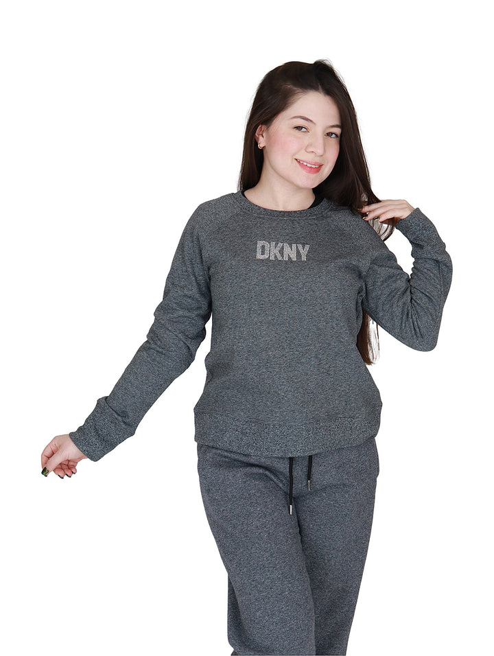 Mujer vistiendo sudadera gris oscuro de cuello redondo con logotipo DKNY en el pecho