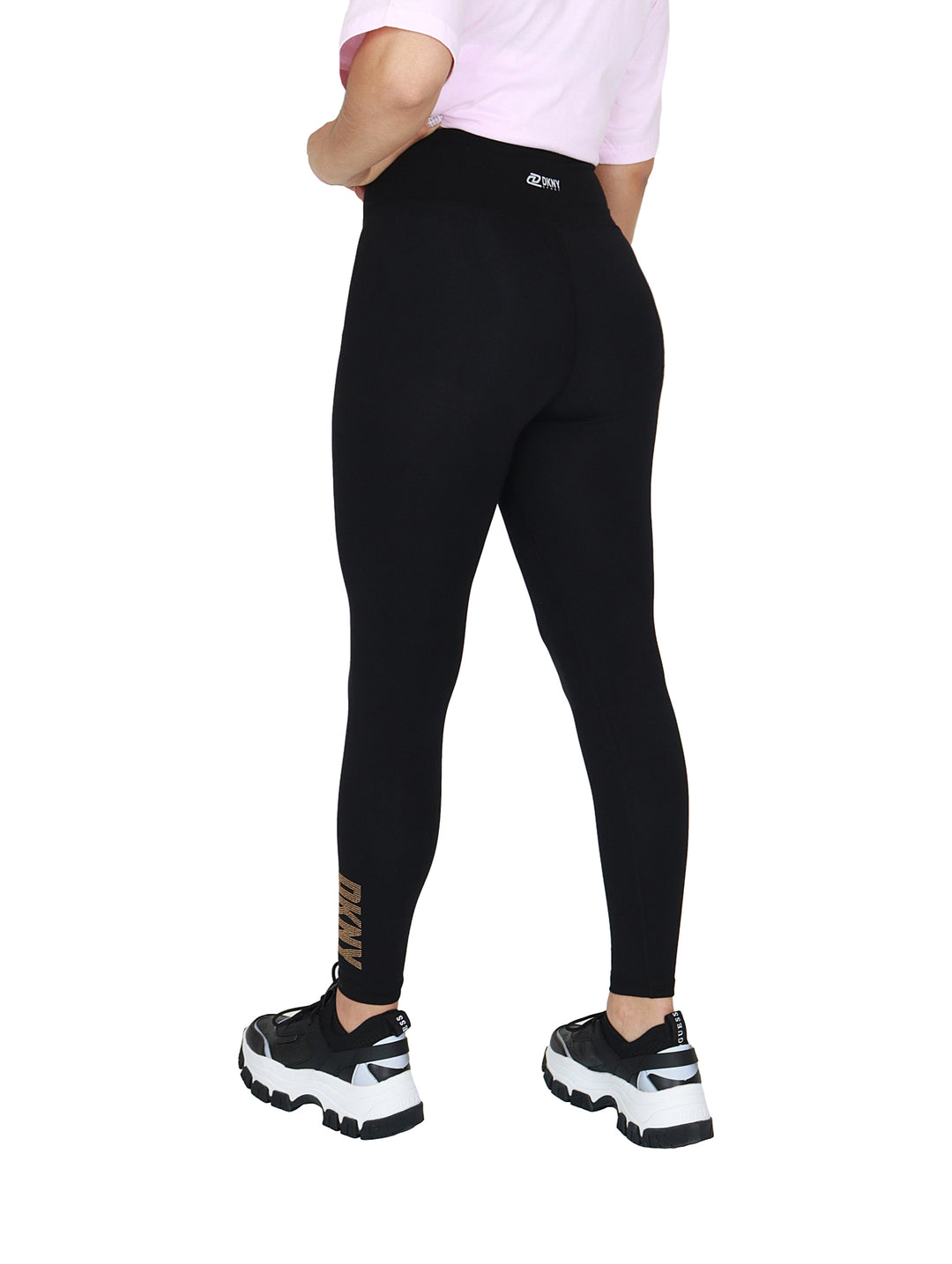 Leggings negros de cintura alta marca DKNY con logo dorado en el tobillo.