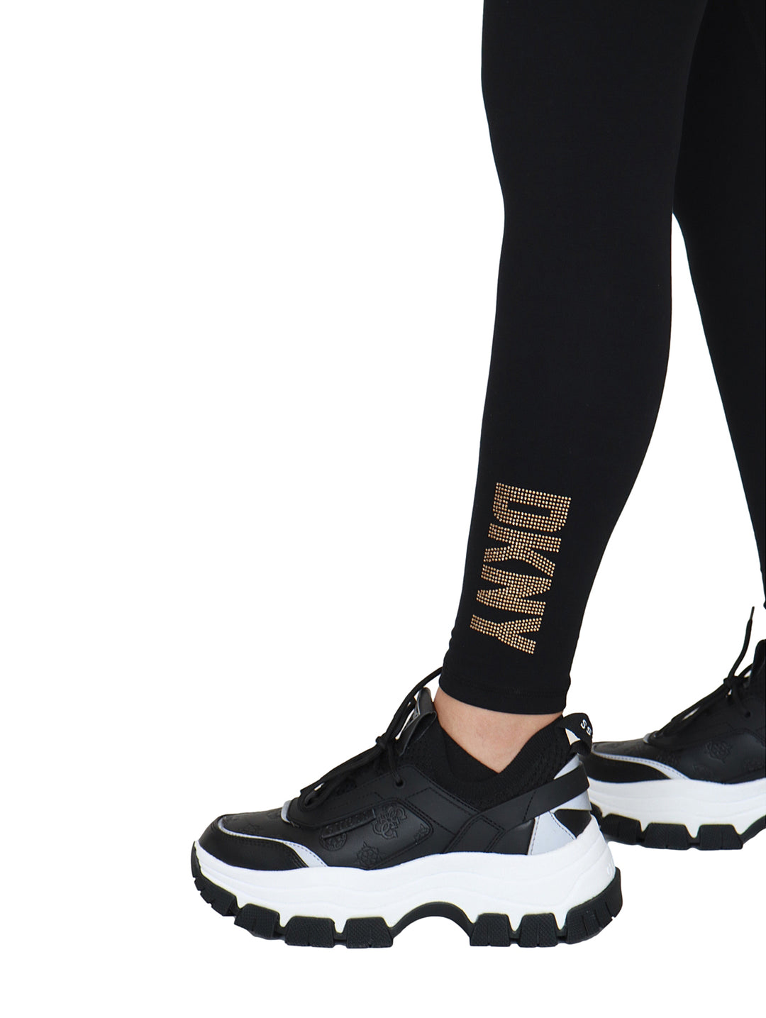 Leggings negros de cintura alta marca DKNY con logo dorado en el tobillo.