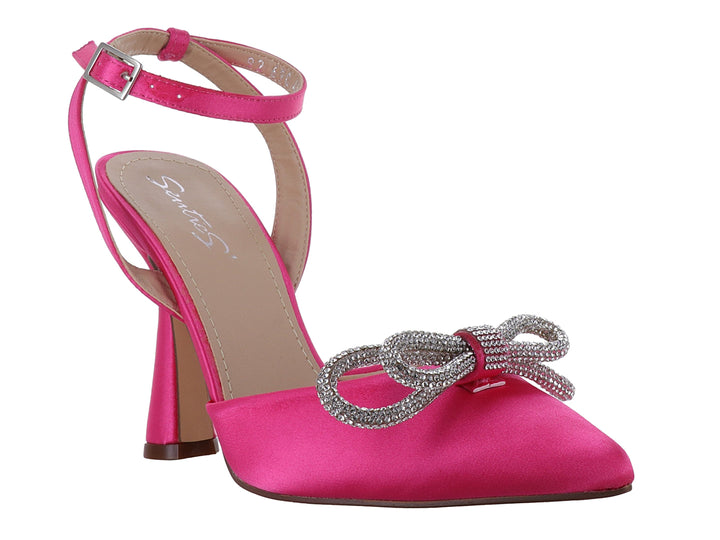 Zapato de tacón color fiusha con acabado satinado, moño decorativo con pedrería plateada y correa al tobillo.