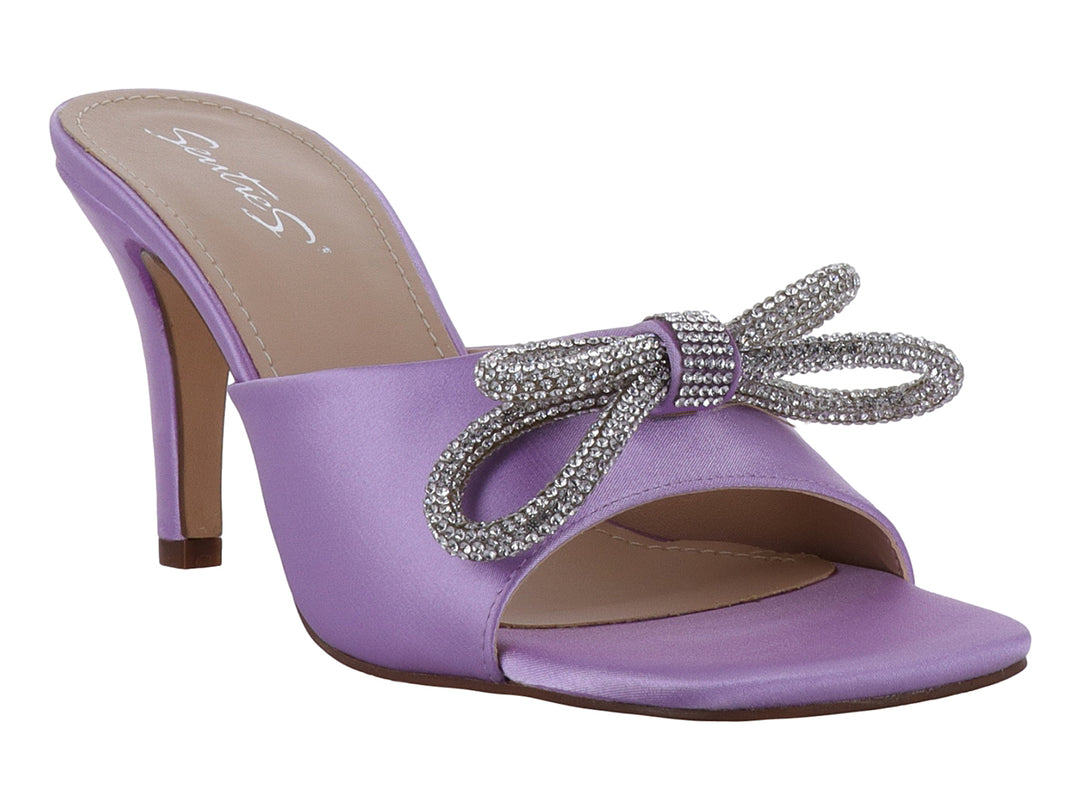 Sandalia de tacón color lavanda con acabado satinado y un moño decorativo con brillantes en la parte frontal.