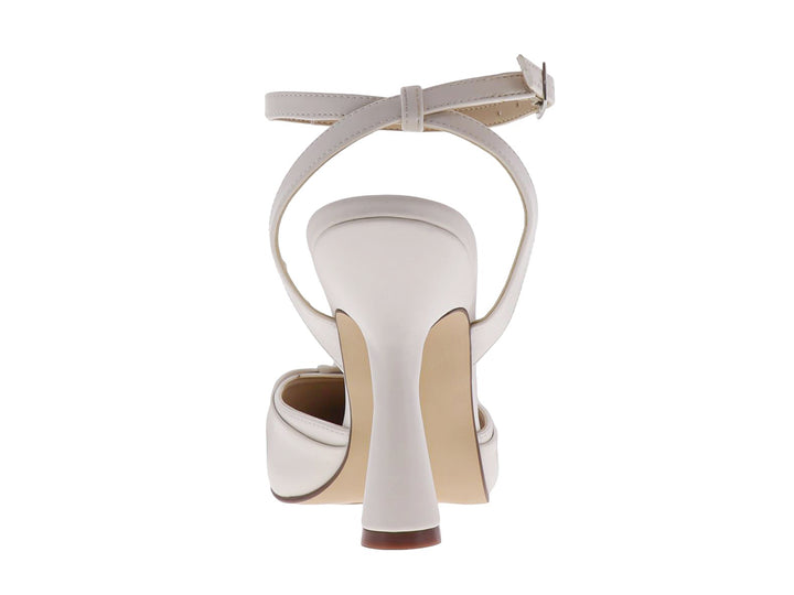 Zapato de tacón color latte con punta cerrada, detalle de nudo frontal y correa ajustable al tobillo.