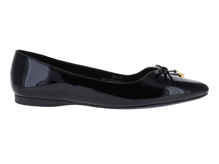 Zapato plano negro de charol brillante con un pequeño moño decorativo con puntas doradas.