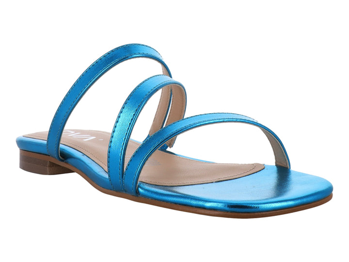Sandalia plana para mujer en color turquesa metálico con tiras cruzadas y suela beige.