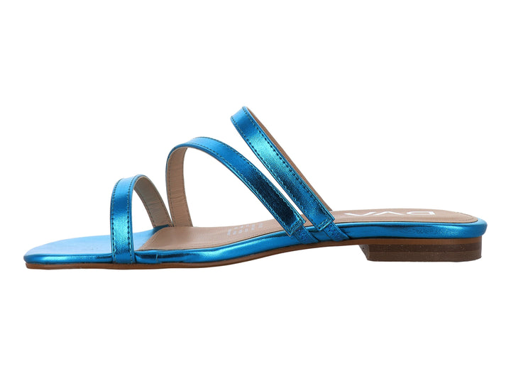 Sandalia plana para mujer en color turquesa metálico con tiras cruzadas y suela beige.