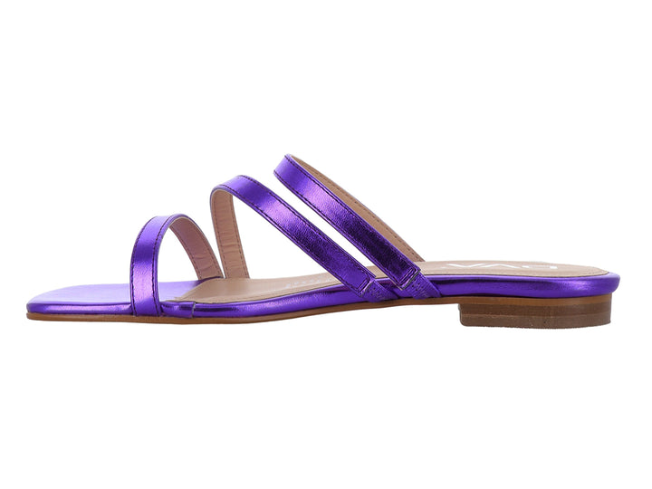 Sandalia plana para mujer en color morado metálico con tiras cruzadas y suela beige.