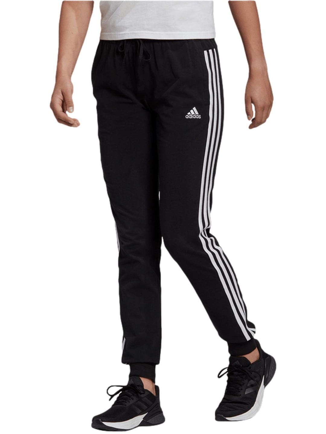 Pantalones deportivos negros Adidas con tres franjas blancas laterales y puños en los tobillos.