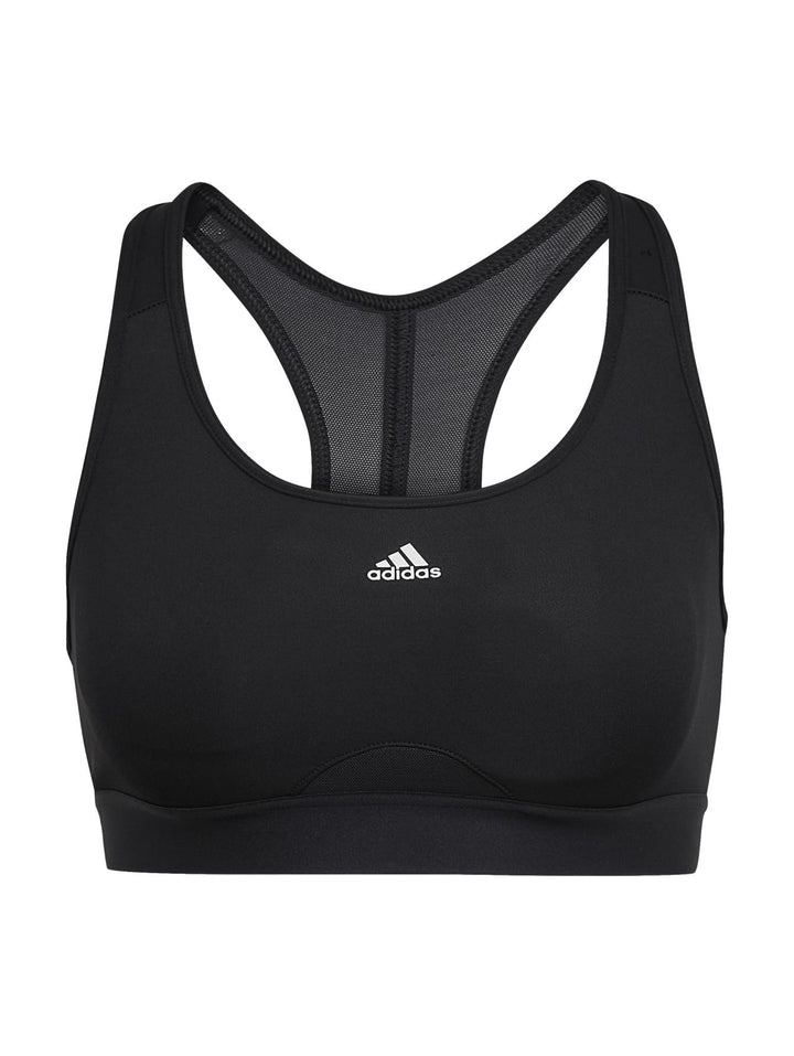 Mujer vistiendo un top deportivo corto color negro de la marca Adidas.