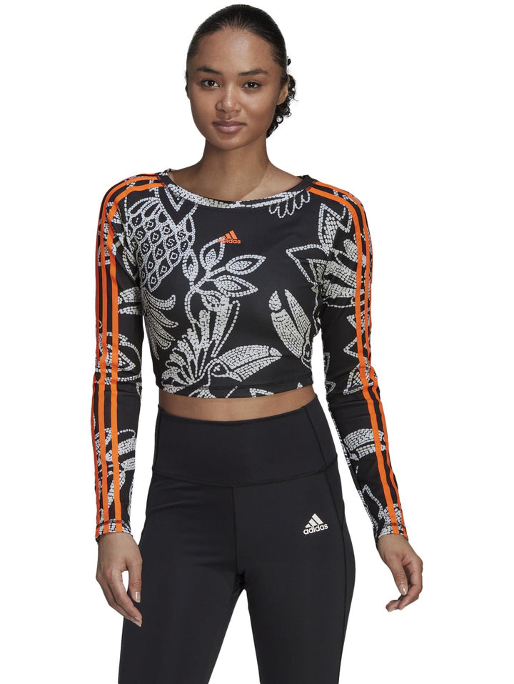 Crop top deportivo Adidas de manga larga en color negro con estampado blanco y franjas naranjas.