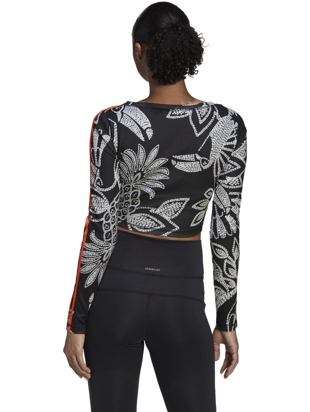 Crop top deportivo Adidas de manga larga en color negro con estampado blanco y franjas naranjas.