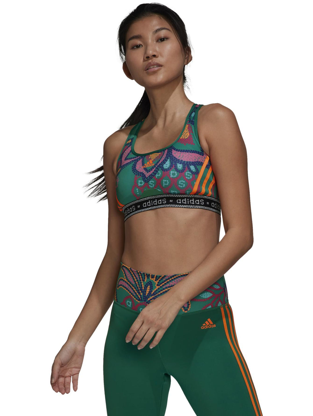 Conjunto deportivo Adidas de mujer en color verde con estampados multicolores y detalles en naranja.