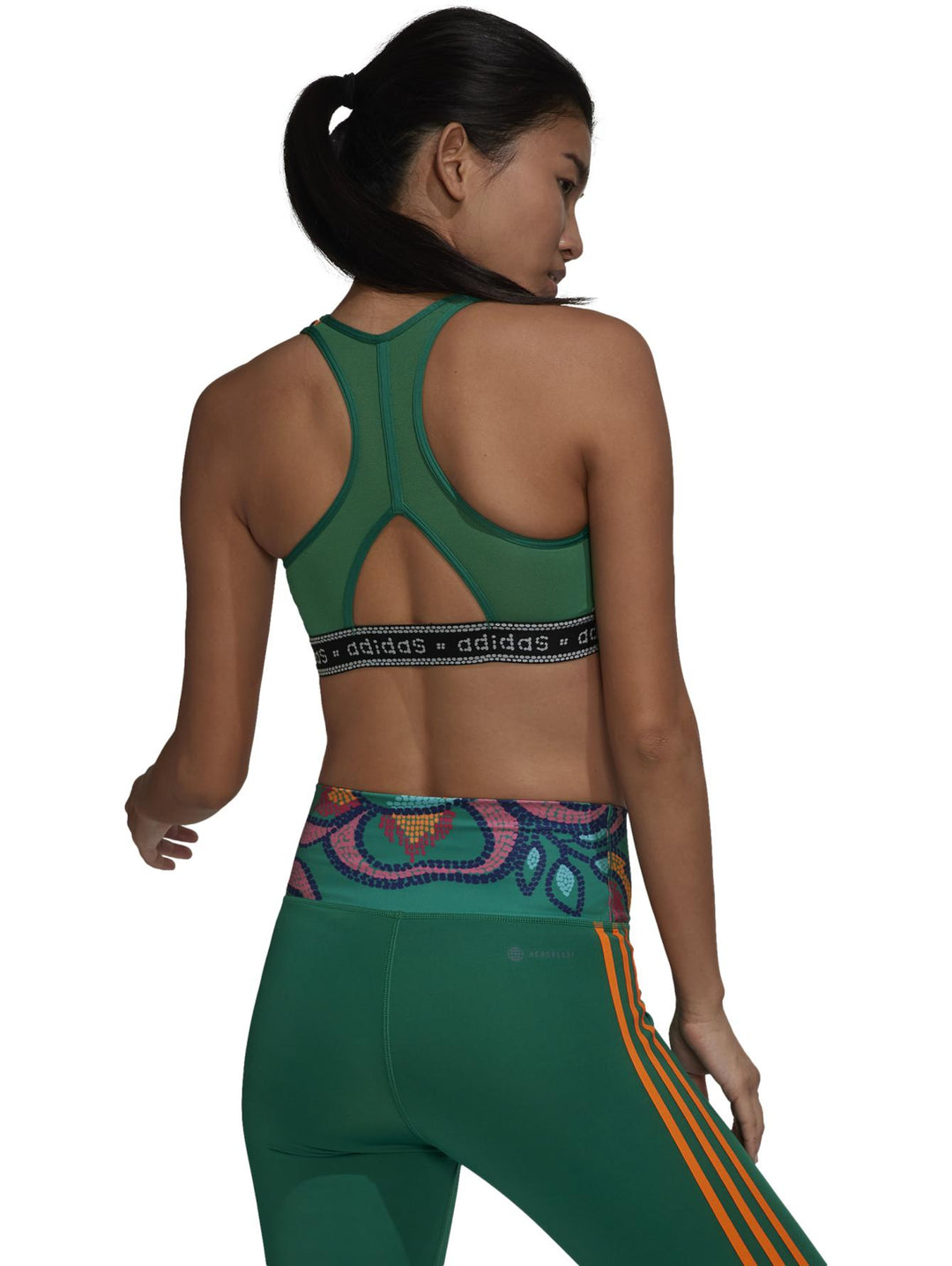 Conjunto deportivo Adidas de mujer en color verde con estampados multicolores y detalles en naranja.