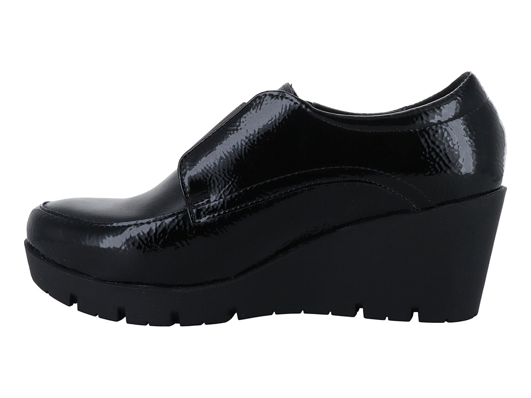 Zapato de piel negro con plataforma alta, acabado brillante y correa frontal con botón decorativo.