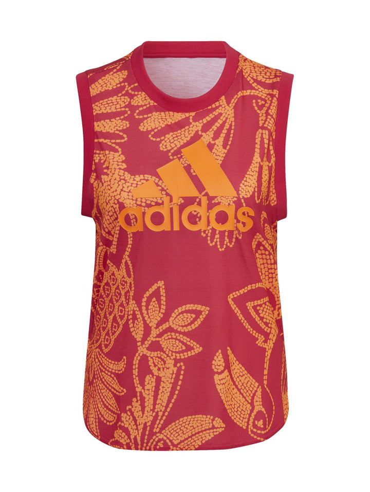Mujer vistiendo camiseta Adidas sin mangas color Vivid Berry y naranja con estampado floral y pantalones a juego.