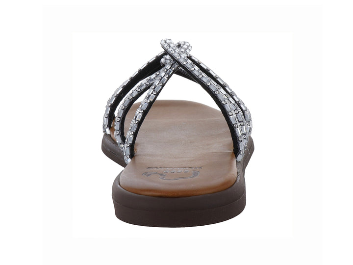 Sandalia plana color plata con tiras brillantes y suela marrón.