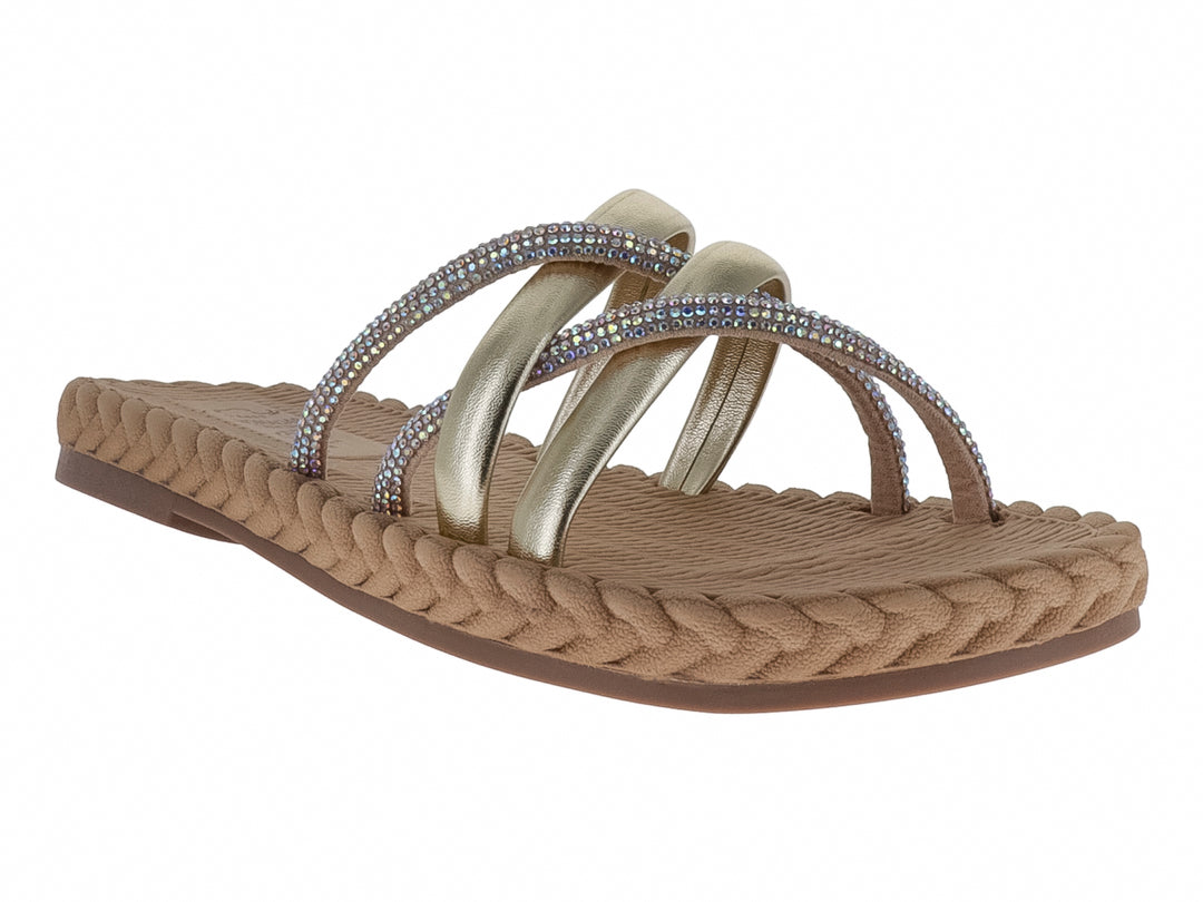 Sandalias Nomadas color oro con tiras metálicas decoradas con pedrería y suela trenzada beige.