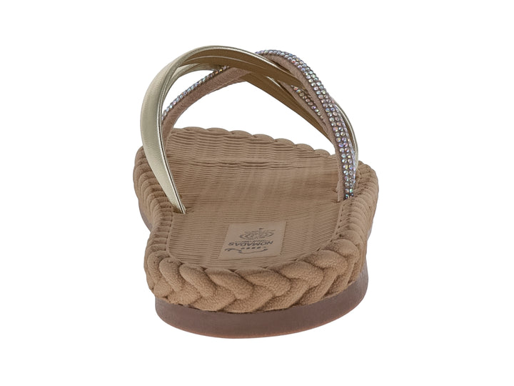 Sandalias Nomadas color oro con tiras metálicas decoradas con pedrería y suela trenzada beige.