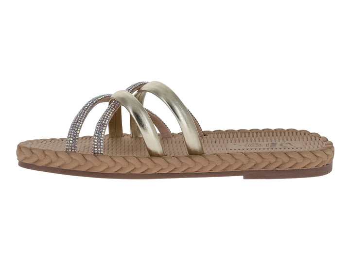 Sandalias Nomadas color oro con tiras metálicas decoradas con pedrería y suela trenzada beige.