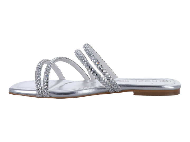 Sandalia plana color plata para niña con tiras decoradas con brillos brillantes.